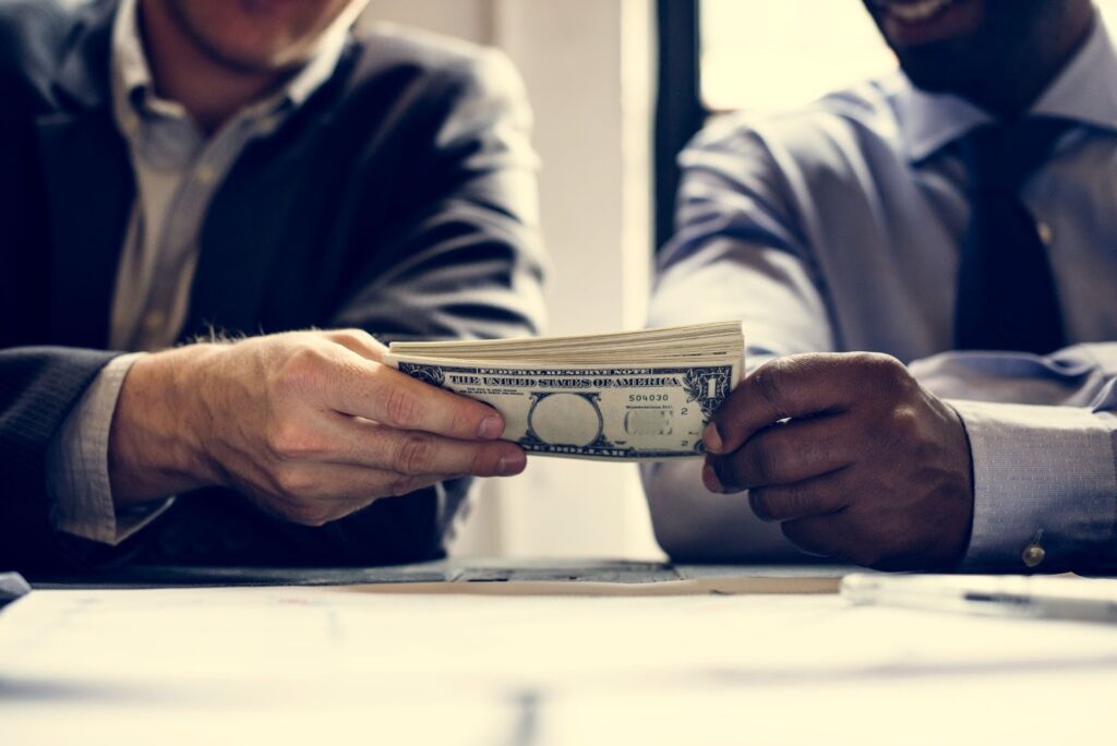 two people holding dollars