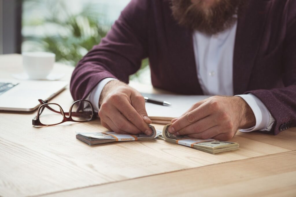 cropped view of businessman counting dollar