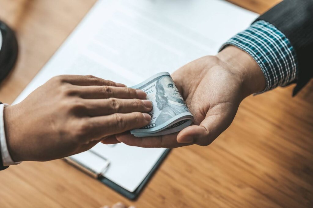 two businessman giving cash