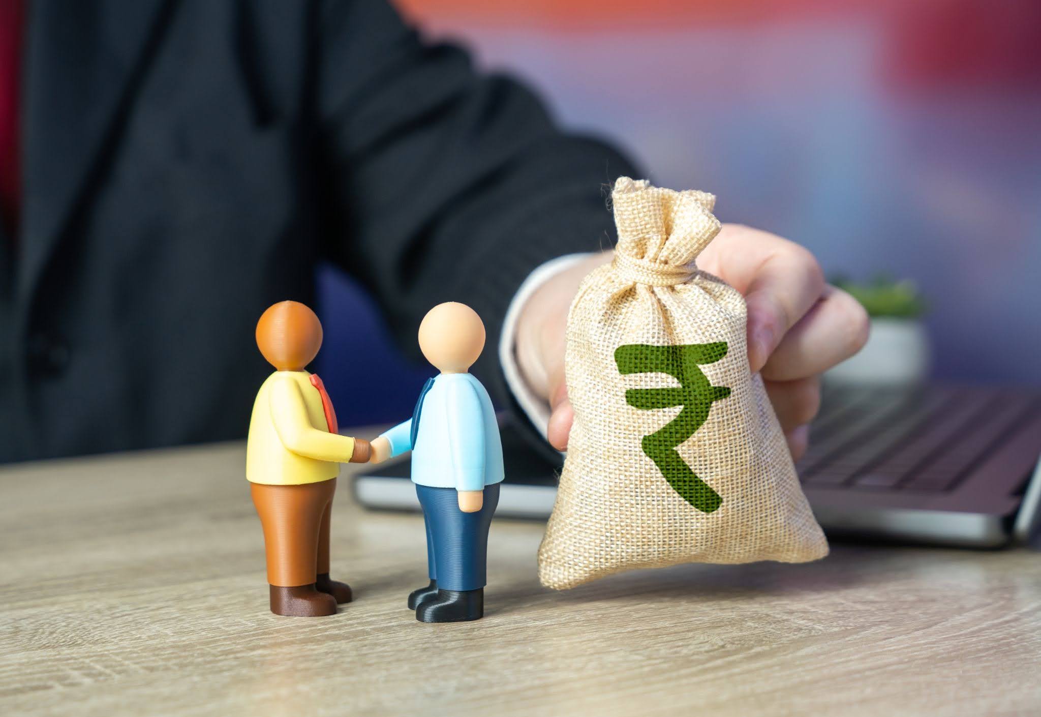 Successful Financial Deal with Figurines and Rupee Symbol