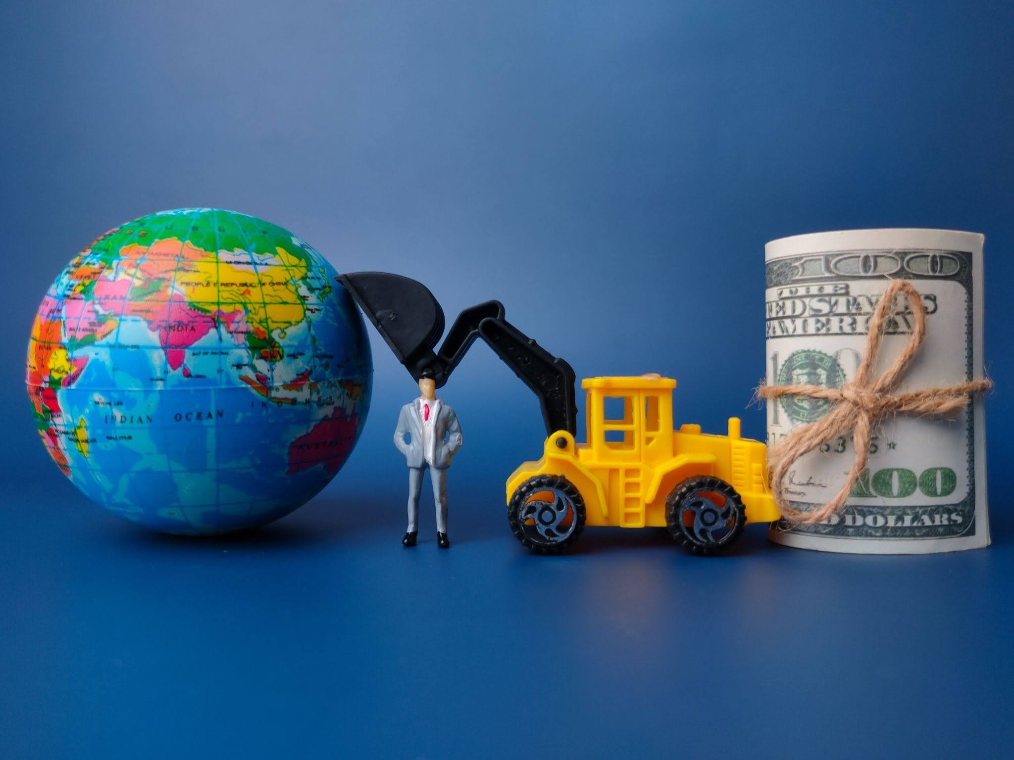 model of earth and equipment machine with dollar