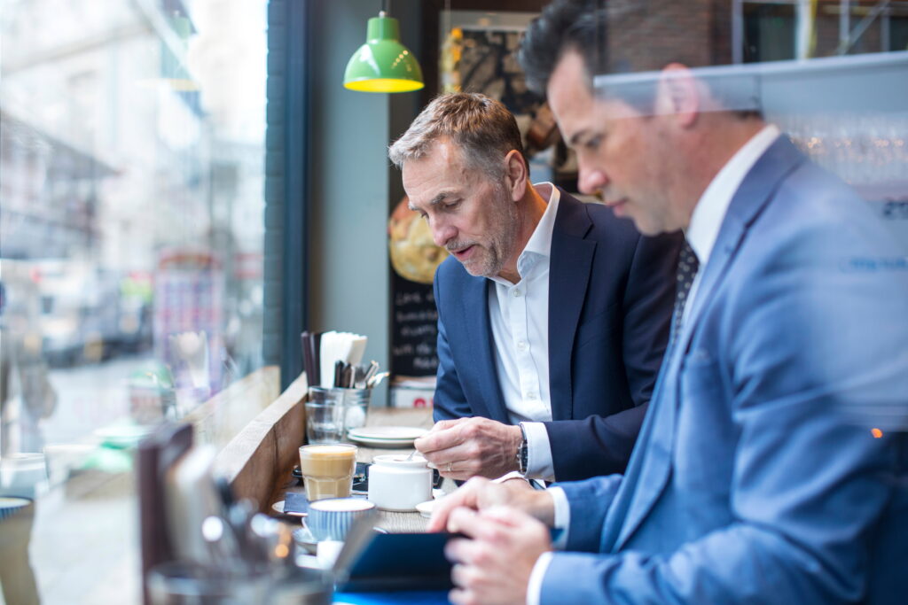 two businessman having working lunch in restaurant.