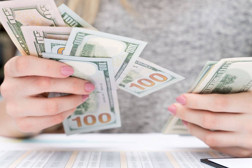 Woman Counting Money at Her Desk