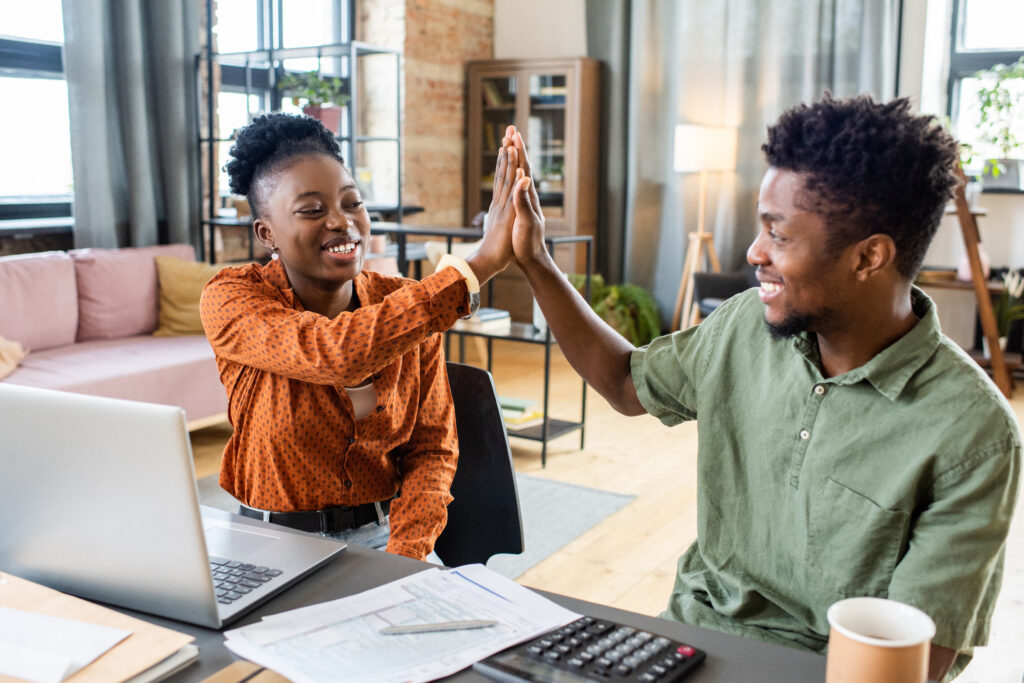 Young Adults High Five at Workspace Desk
