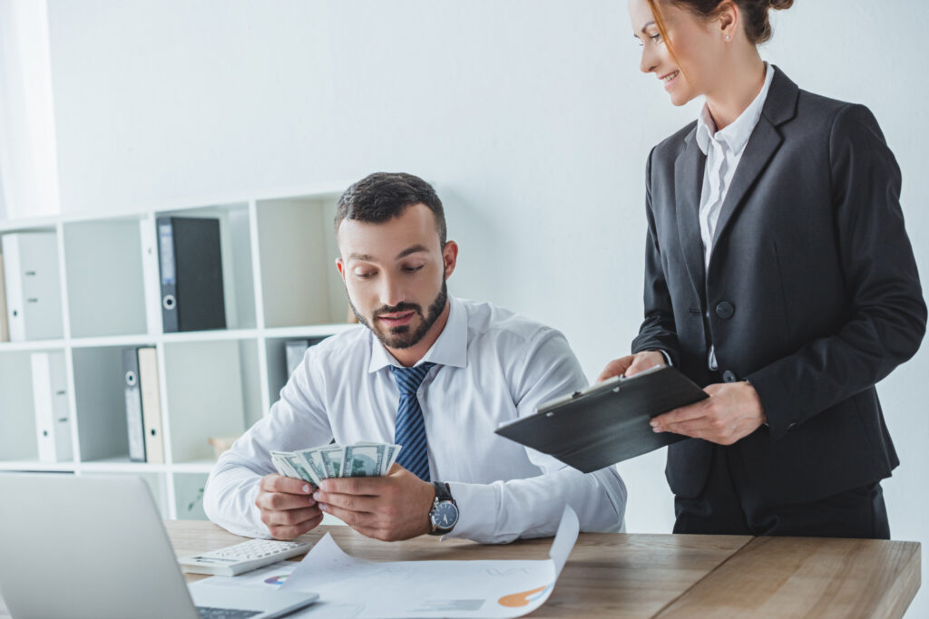 attractive financier showing clipboard to colleague in office