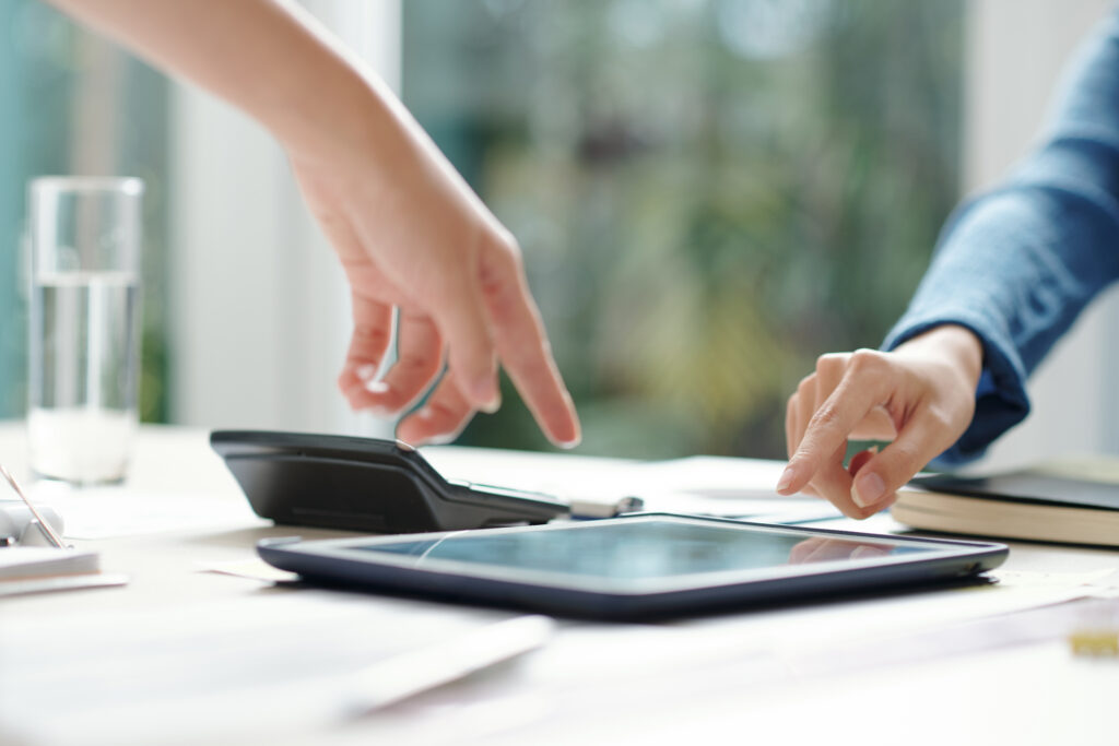 Business colleagues pointing at screen of digital tablet with important data