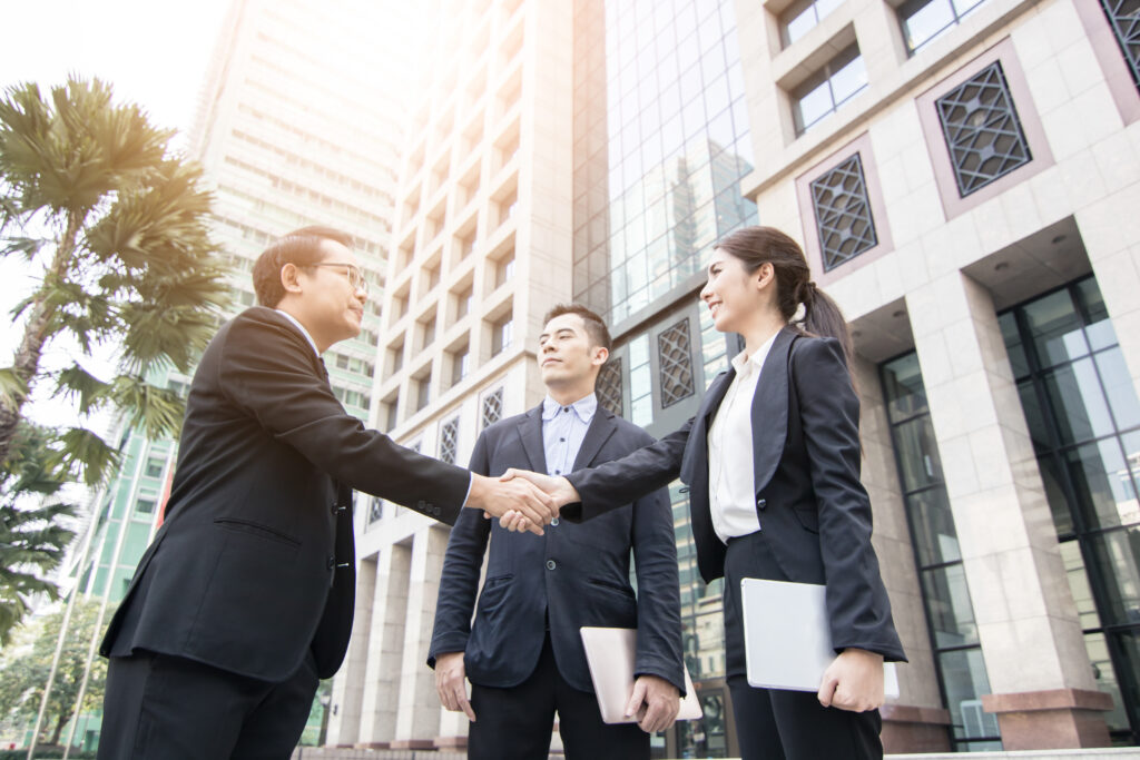 business team shaking hands outside office
