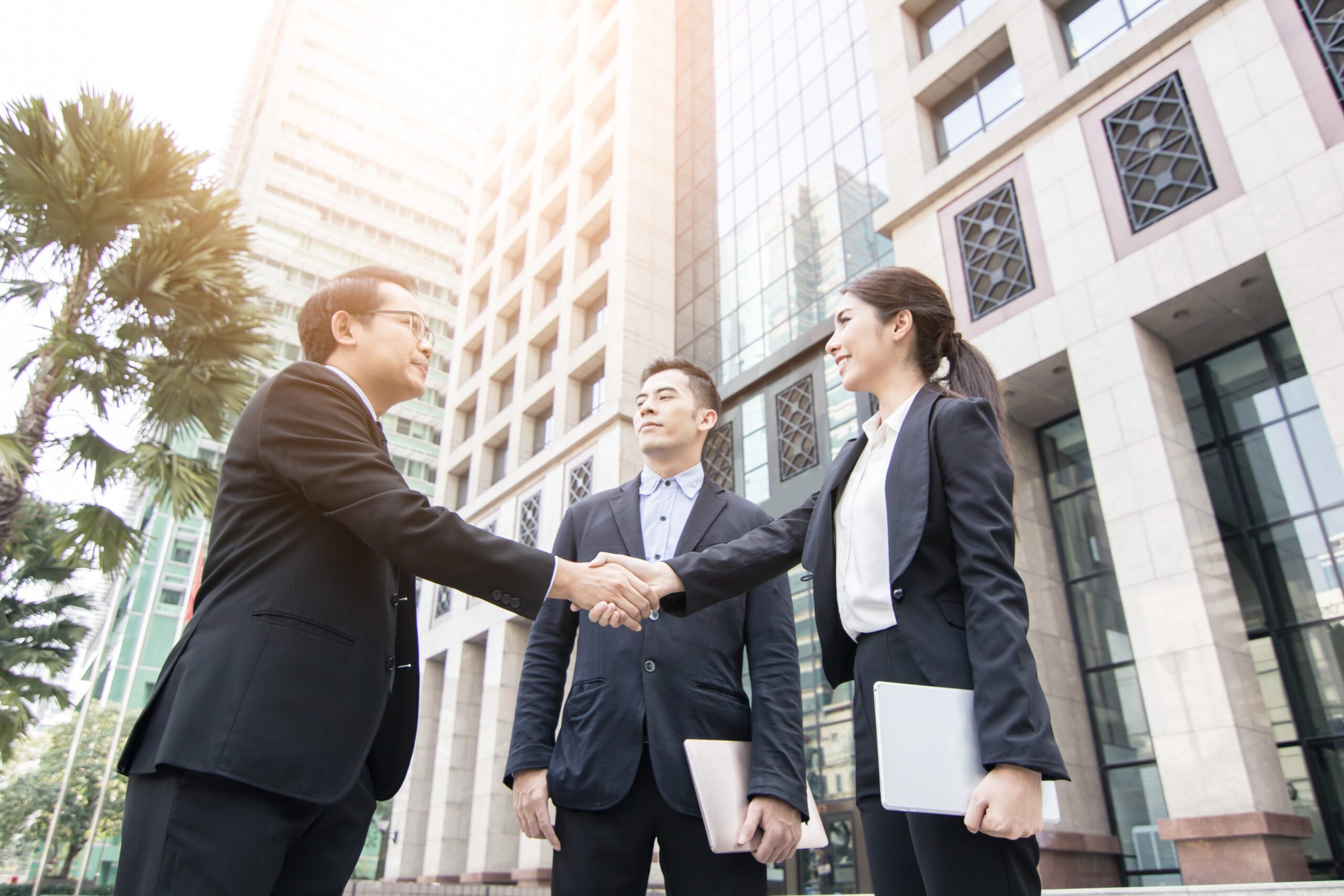 business team shaking hands outside office