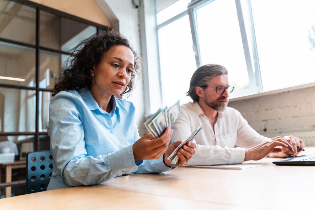 man and woman counting bills in the bank office