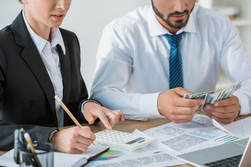 cropped image of accountants calculating dollars in office