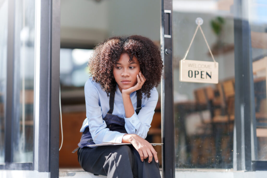 Female shopkeeper sitting stressed out at the store